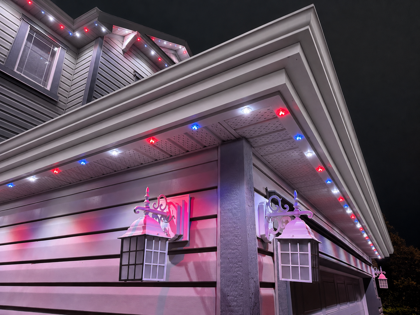 Home with warm permanent LED soffit lighting glowing at night